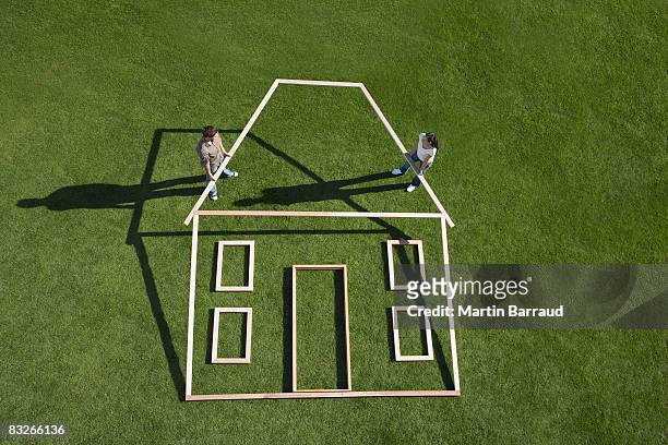 couple building house outline - build together stockfoto's en -beelden