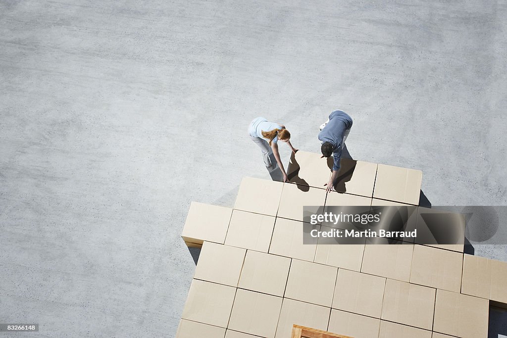 Couple building house outline on sidewalk