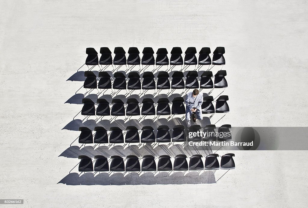 Businessman sitting in office chairs on sidewalk