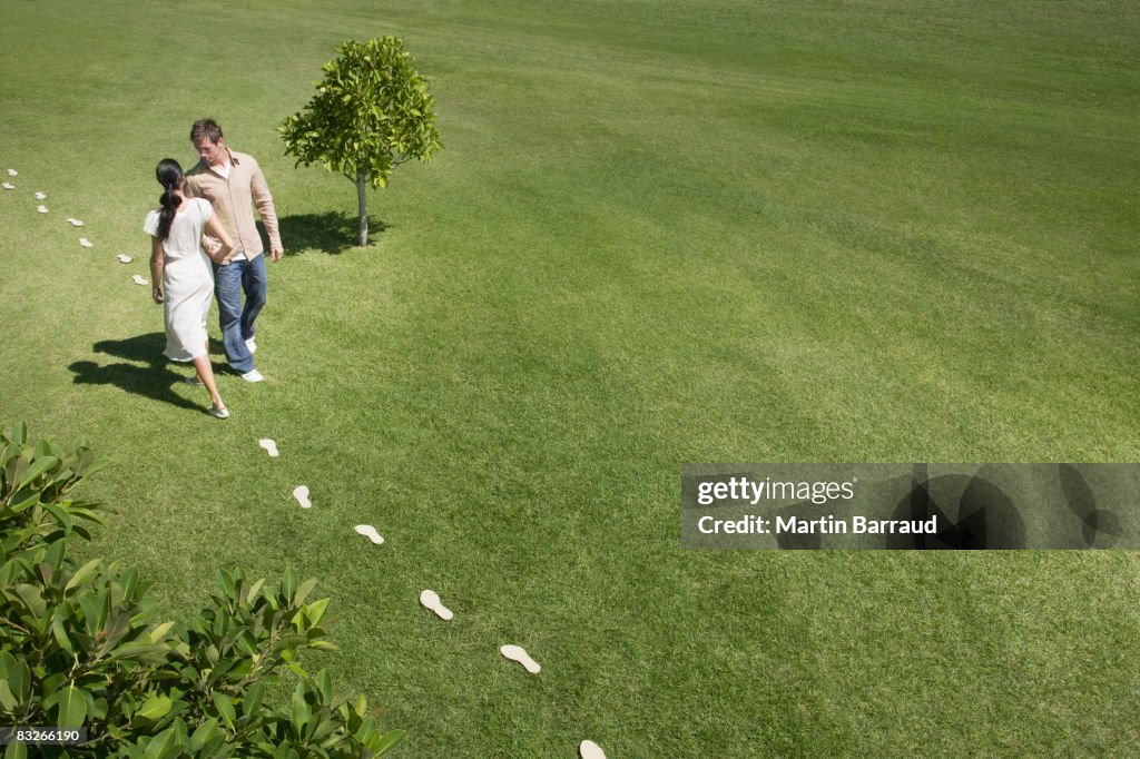 Man and woman walking leaving trail of footprints