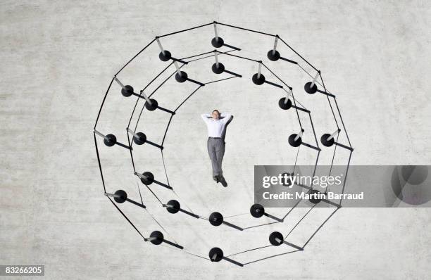 businessman laying in circle of cordon posts - 邊界 人造�建築 個照片及圖片檔