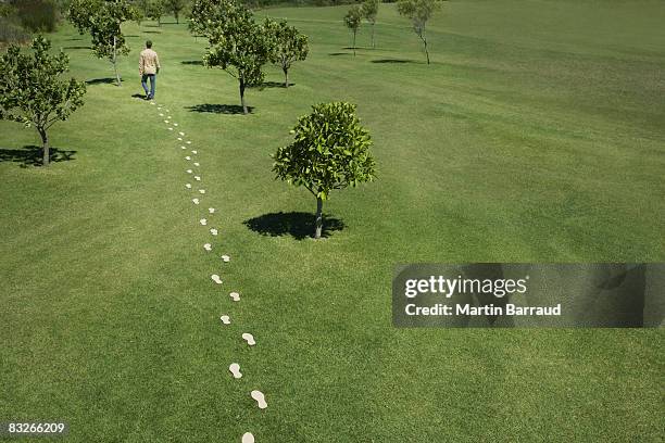 man walking leaving trail of footprints - fotspår bildbanksfoton och bilder
