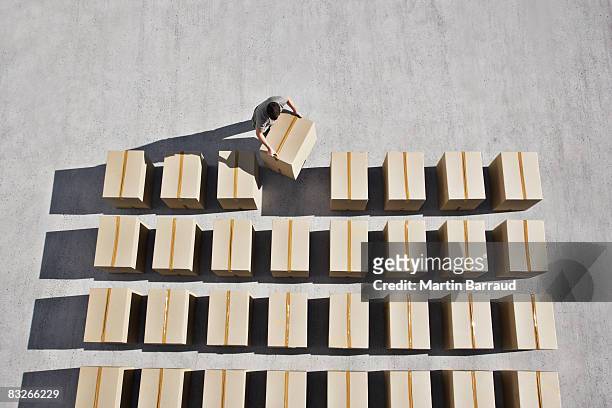 man placing box into line - double stock pictures, royalty-free photos & images