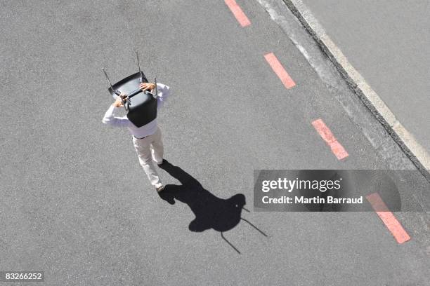geschäftsmann, tragen bürostuhl in straße - perspektivenwechsel stock-fotos und bilder