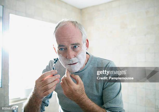 senior man shaving - rasieren stock-fotos und bilder