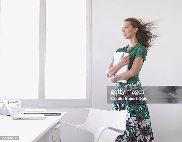 femme d'affaires tenant des papiers avec le vent qui souffle - woman fresh air photos et images de collection