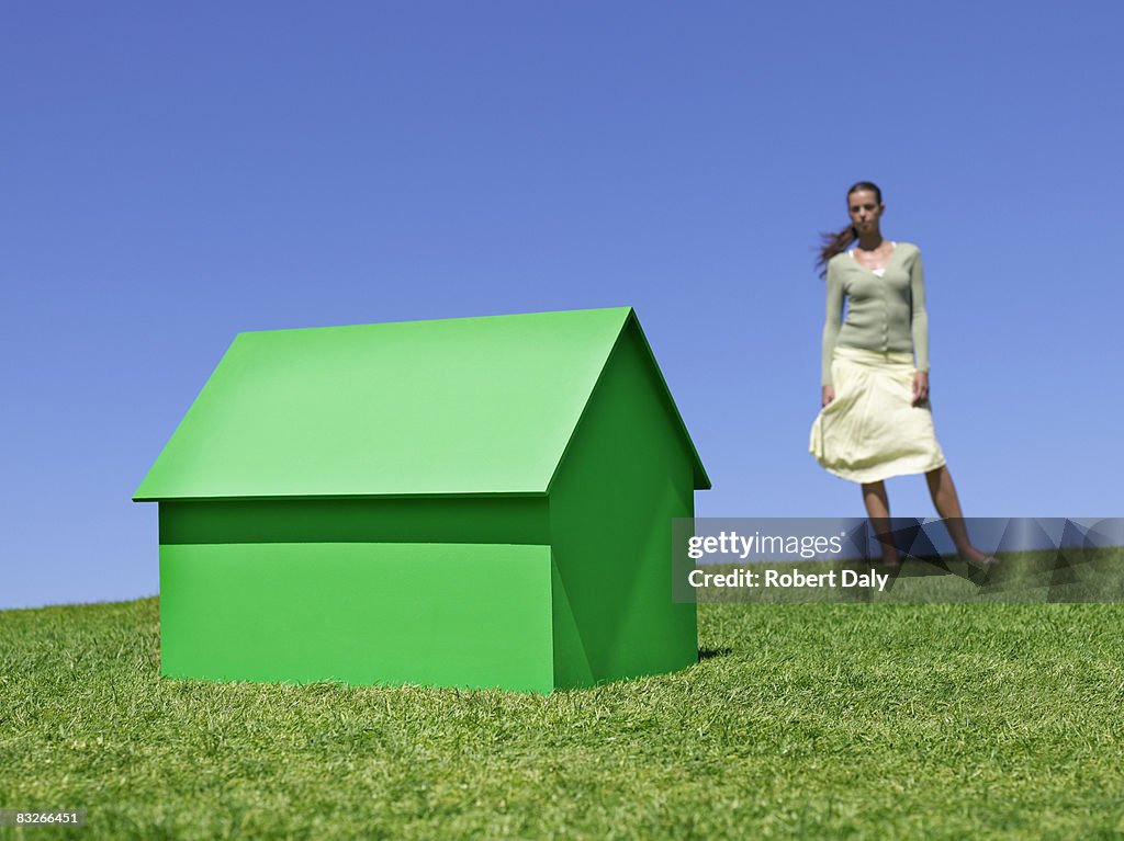 Femme debout près de Petite Maison témoin