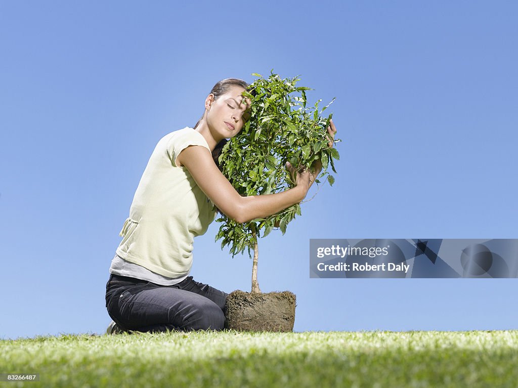 Woman hugging small tree
