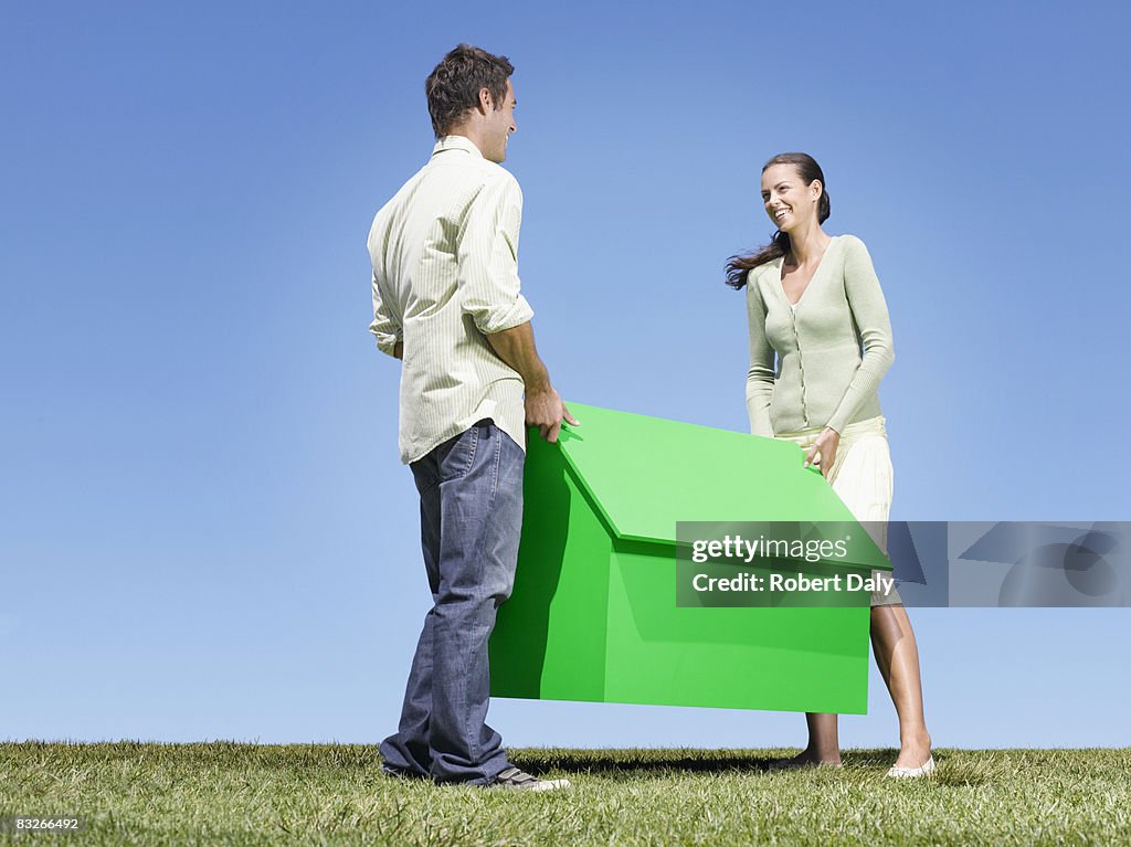 Couple carrying small model house