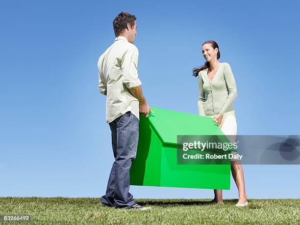 couple carrying small model house - single object stock pictures, royalty-free photos & images