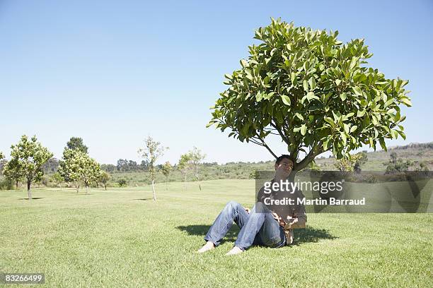 男に座るの木の日陰 - 陰 ストックフォトと画像