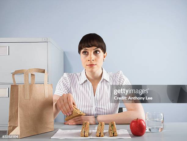 businesswoman eating healthy lunch at desk - workplace canteen lunch stock pictures, royalty-free photos & images