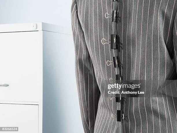 bulldog clips tightening businesswoman's suit jacket - bulldog clip imagens e fotografias de stock