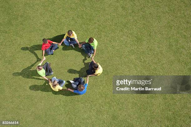 gruppo di bambini seduti sull'erba in un cerchio formazione - bambini seduti in cerchio foto e immagini stock