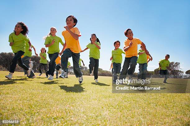 group of children running in park - children running stock pictures, royalty-free photos & images