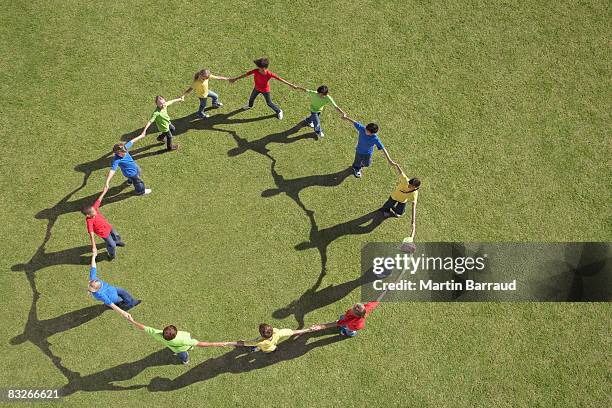 group of children walking in circle holding hands - holding hands bildbanksfoton och bilder