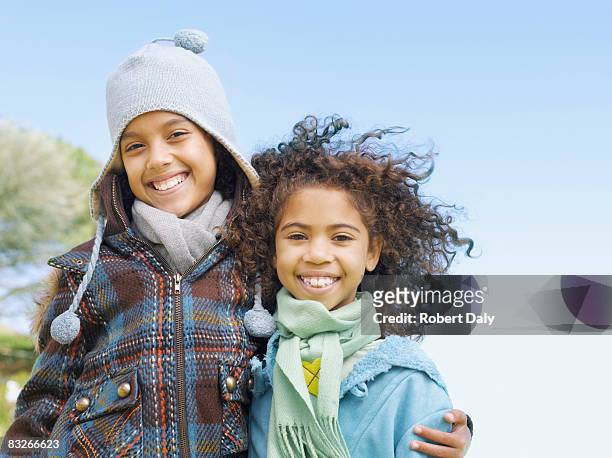 due giovani sorelle abbracciare in inverno - casacca foto e immagini stock