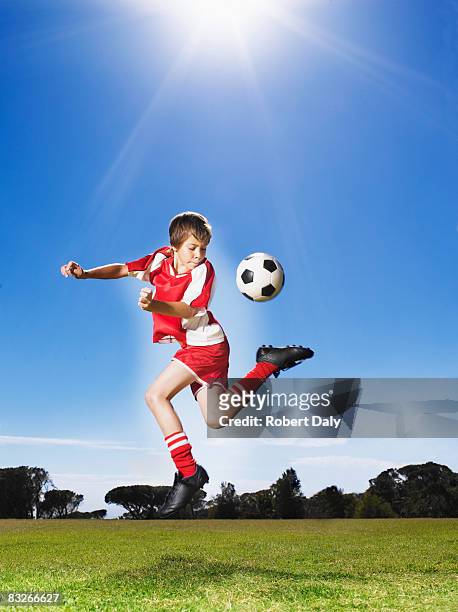 young boy in uniform kicking soccer ball - ballkid stock pictures, royalty-free photos & images