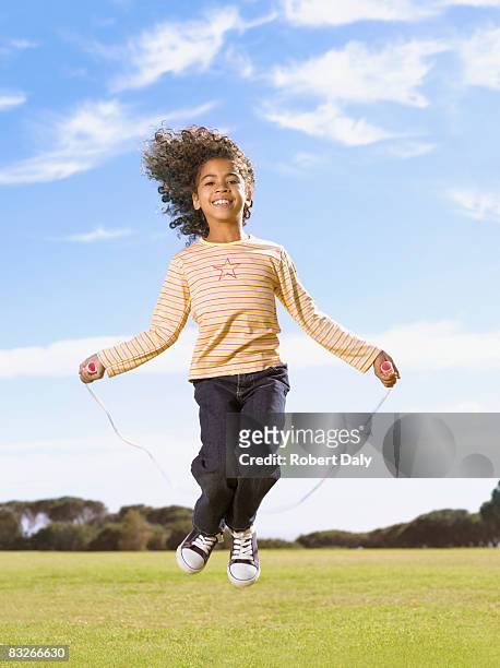 young girl jumping rope - girl jumping stockfoto's en -beelden