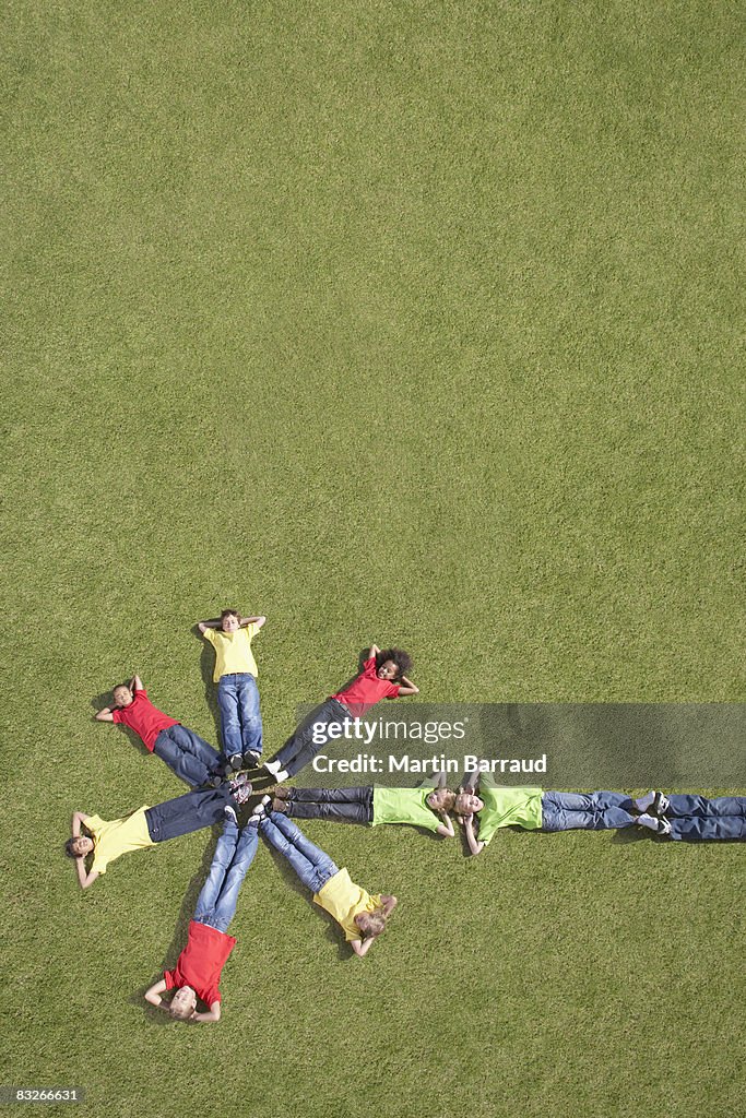 Group of children laying on grass in formation