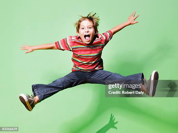 young boy jumping in mid-air - jumping for joy stockfoto's en -beelden