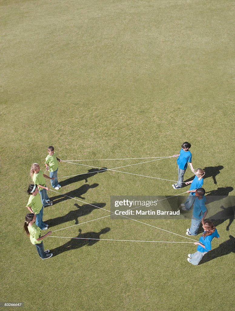 Group of children playing with string in park