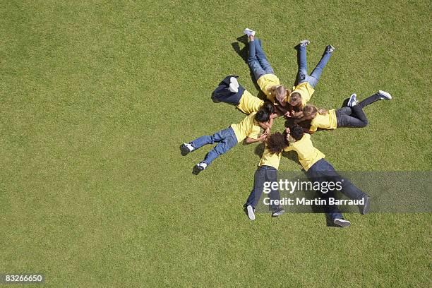 group of children laying on grass in circle formation - lying on front stock pictures, royalty-free photos & images