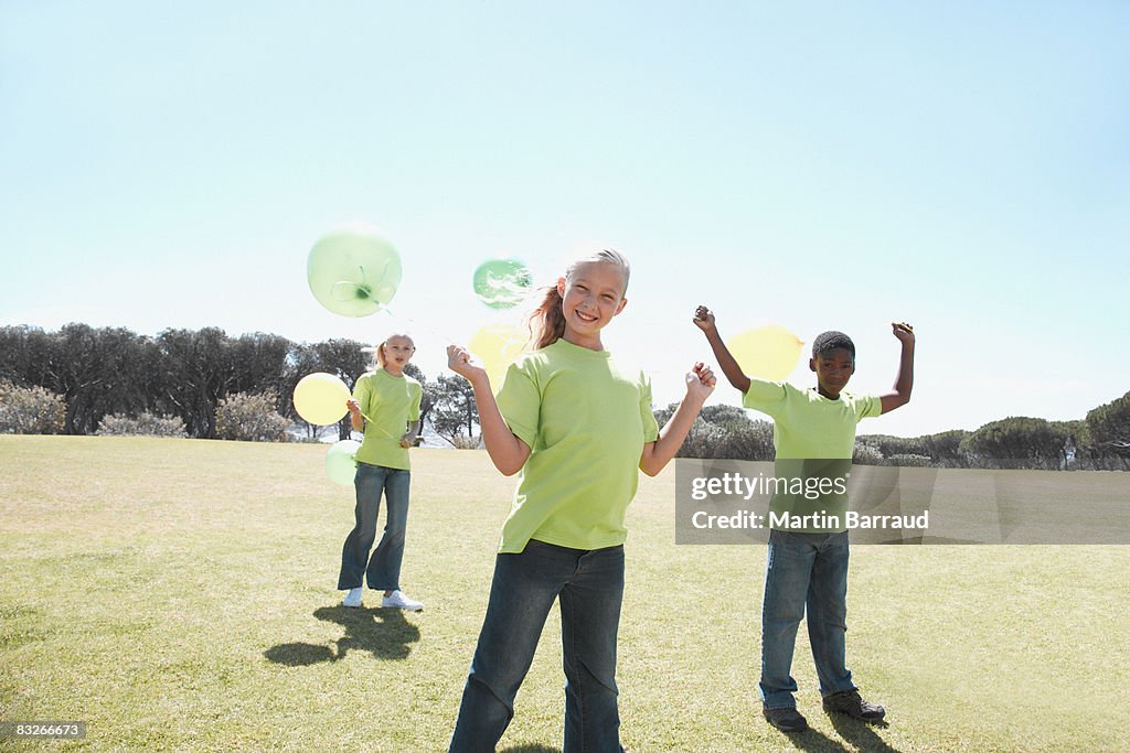 Three children holding balloons outdoors