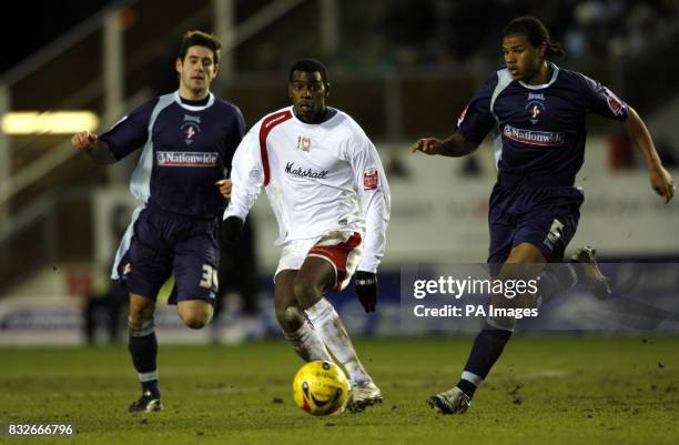 Dons' Izale McLeod is challenged by Swindon's Michael Timlin and Jerel Ifil during the Coca-Cola League Two match at the National Hockey Stadium,...