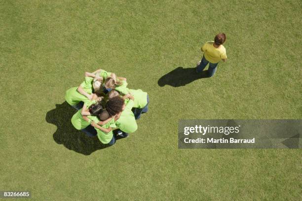 grupo de niños en huddle con un niño excluidos - exclusión fotografías e imágenes de stock