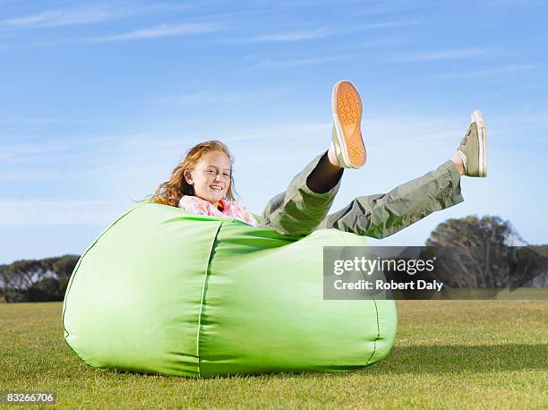 young girl relaxing in bean bag outdoors - bean bag stock pictures, royalty-free photos & images