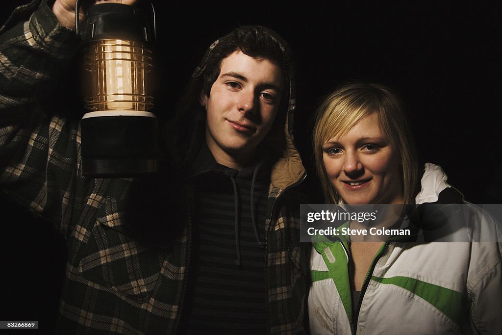 Teenage couple with camping lantern