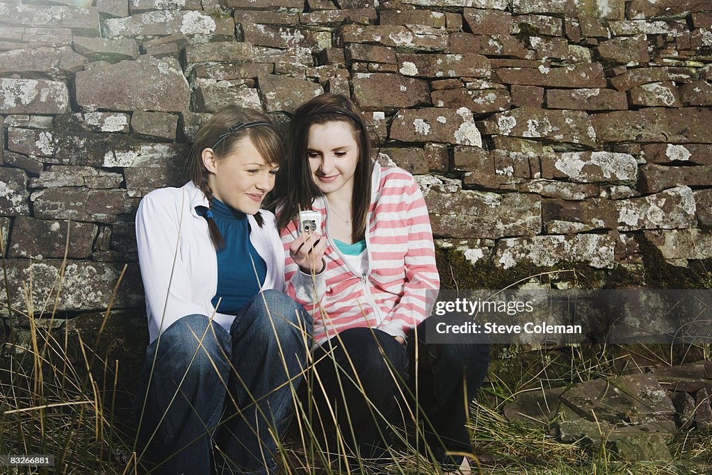 Teenage girls using digital camera