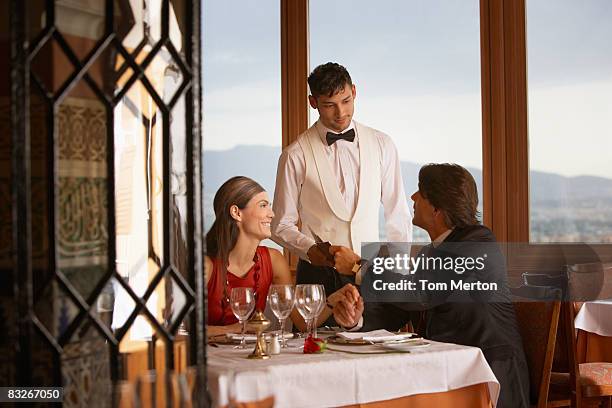 waiter serving couple in elegant restaurant - classy stockfoto's en -beelden