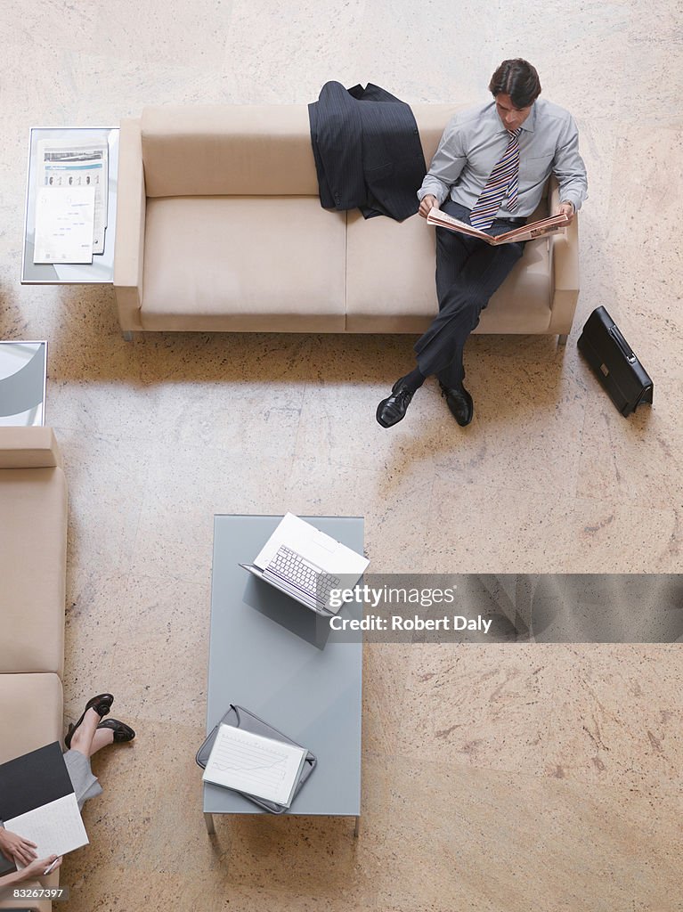 Businessman reading newspaper in lobby