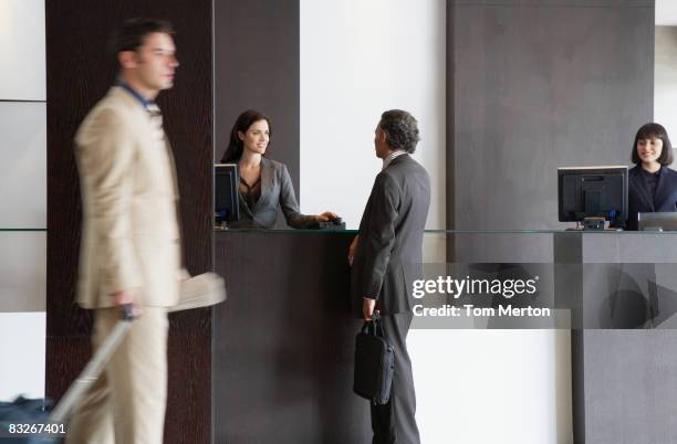 customer service representative helping businessman - hotelreceptie stockfoto's en -beelden
