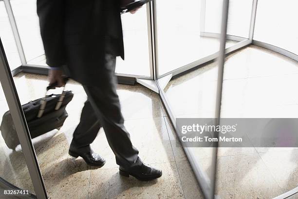 uomo d'affari con valigetta con porta girevole - revolving door foto e immagini stock