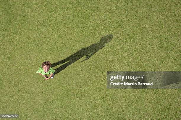 boy standing in grass looking up - person look up from above stock pictures, royalty-free photos & images