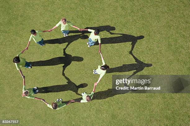group of children holding hands in a circle - hold hands circle stock pictures, royalty-free photos & images