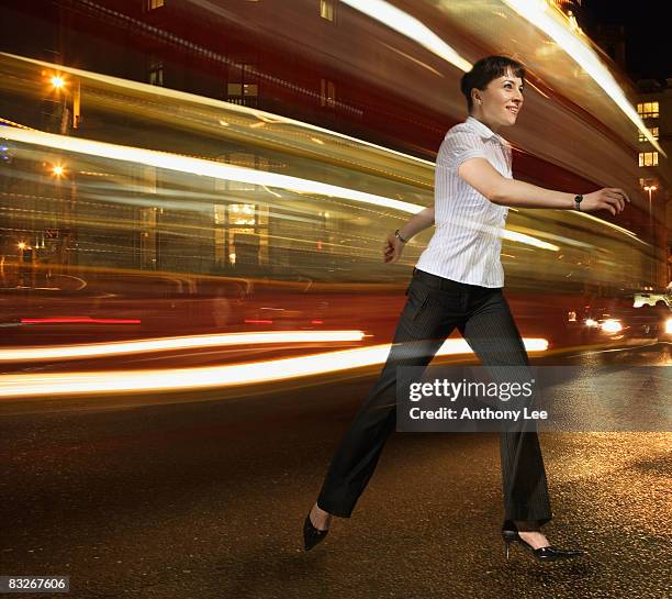 businesswoman running with lights streaking behind - vehicle light stock pictures, royalty-free photos & images