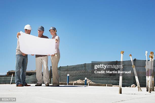 architect viewing blueprints with home owners - real estate developer stock pictures, royalty-free photos & images