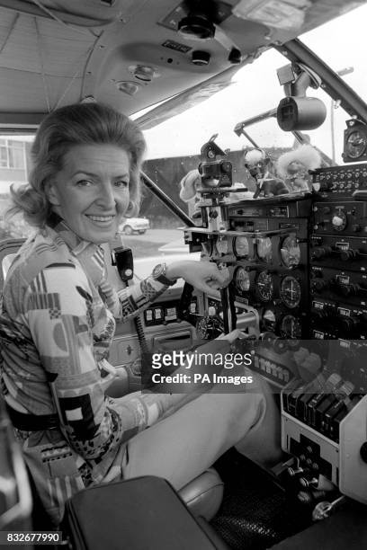 Amid an imposing array of controls, lone airwoman Sheila Scott finds room for her lucky mascots in her new Piper Aztec aircraft as she makes final...