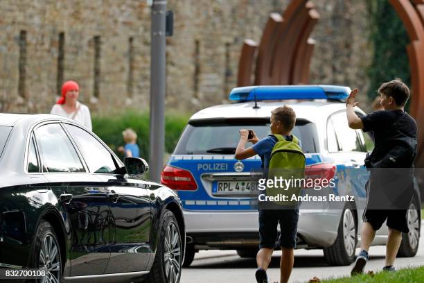 Children take photos of the car leaving with German Chancellor and head of the German Christian Democrats Angela Merkel after an election rally at...