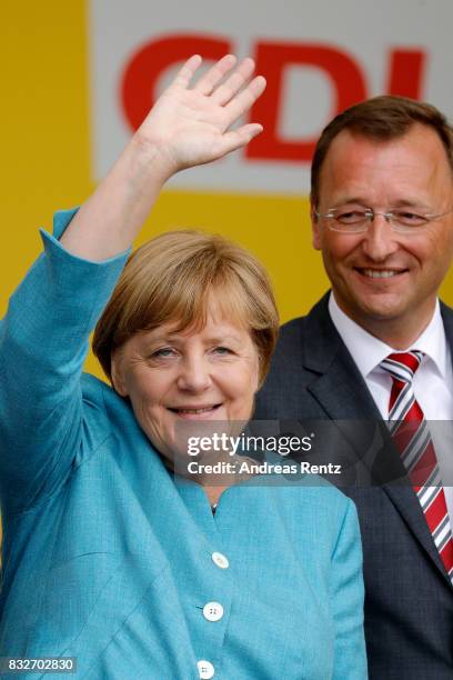 German Chancellor and head of the German Christian Democrats Angela Merkel and Josef Oster, candidate for the German parliament, greet supporters...