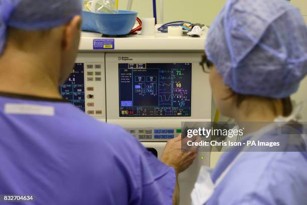 An anaesthetist checks his equipment during a Laparoscopic Anterior Resection on a patient at the Royal Hampshire County Hospital in Winchester,...