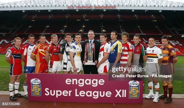Former Welsh International player Scott Quinnell holds the trophy as he lines up with team captains Hull KR's James Webster, Wakefield Trinity...