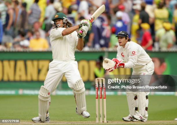 Australian batsman Andrew Symonds hits a boundary during his innings of 156 watched by England wicketkeeper Chris Read in the 4th Test match between...