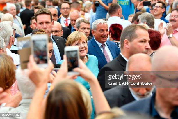 German Chancellor Angela Merkel is photographed by supporters as she arrives to address an election campaign rally of the Christian Democratic Union...