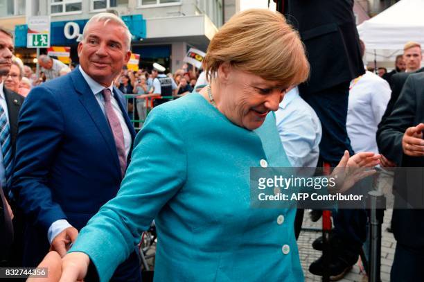 German Chancellor Angela Merkel shakes hands as she arrives to address an election campaign rally of the Christian Democratic Union in Heilbronn,...