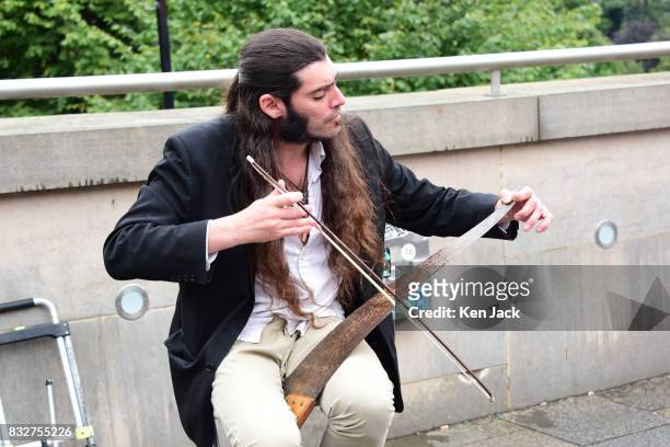 Street performer plays a saw during the Edinburgh Festival Fringe, on August 16, 2017 in Edinburgh, Scotland. The Fringe is celebrating its 70th...